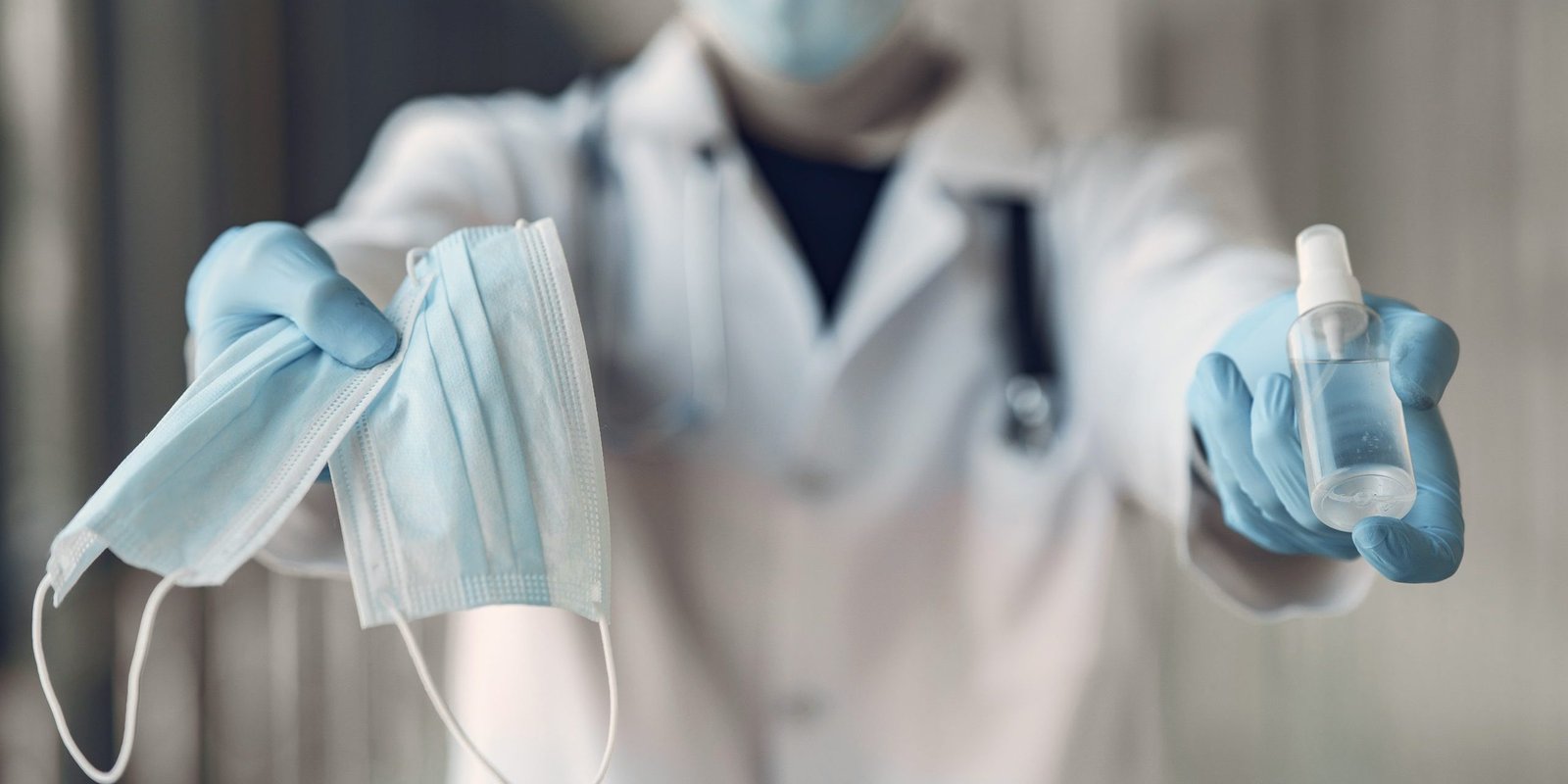 Doctor hold the antiseptic and masks in his hand